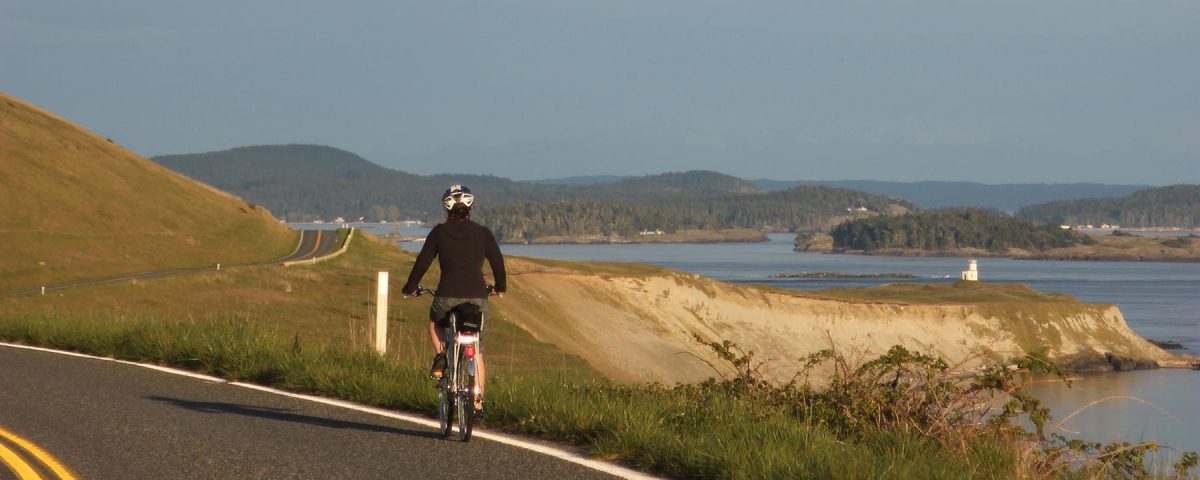 San Juan Island bike renter with Cattle Point Lighthouse in the background